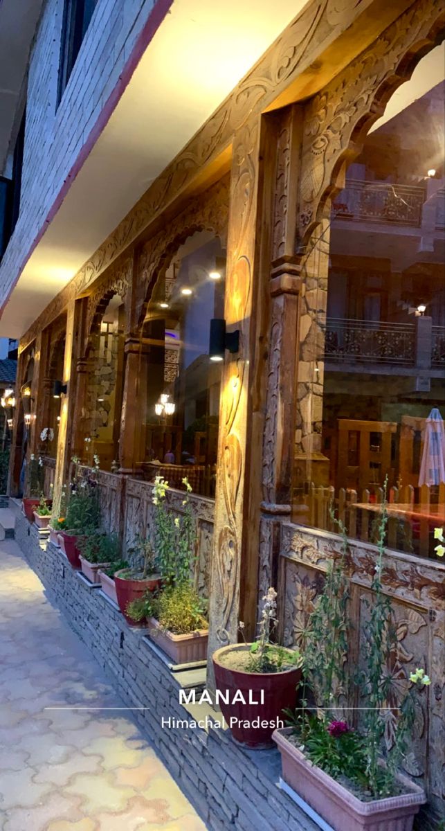 an outside view of a restaurant with potted plants