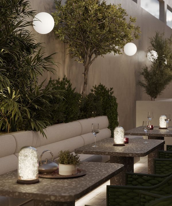 an outdoor dining area with tables and chairs, lit up by lights hanging from the ceiling