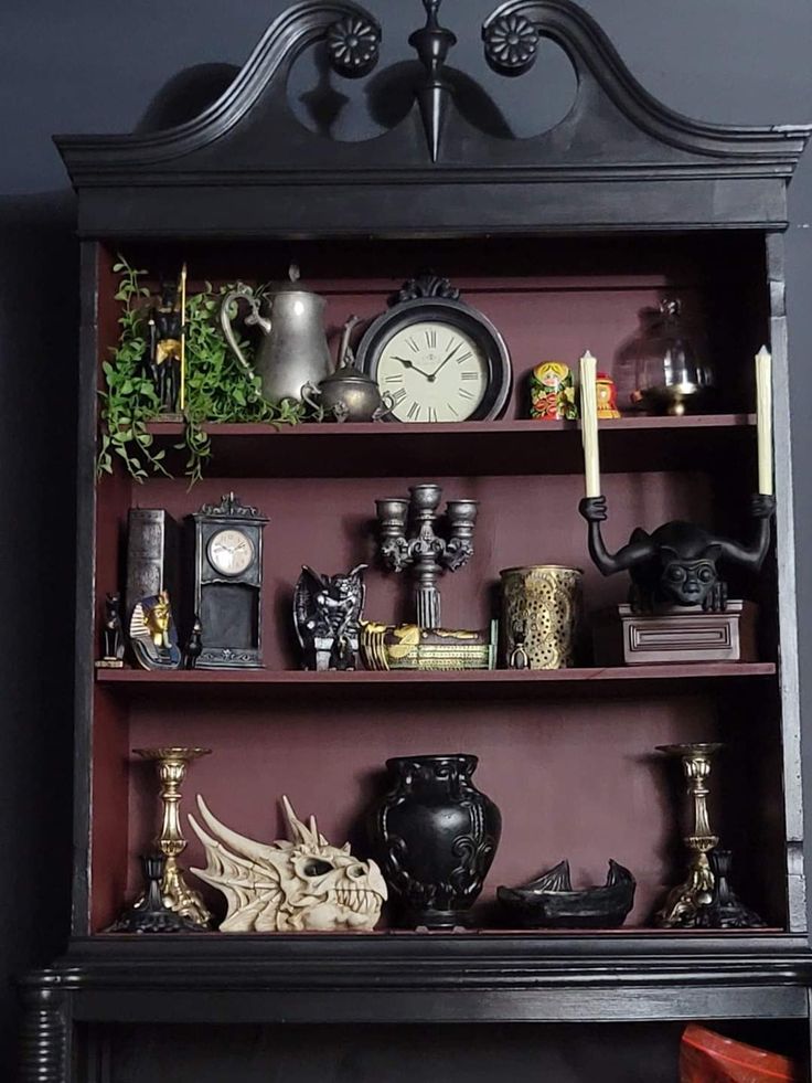 a bookcase with many items on it and a clock above the top shelf in front of it