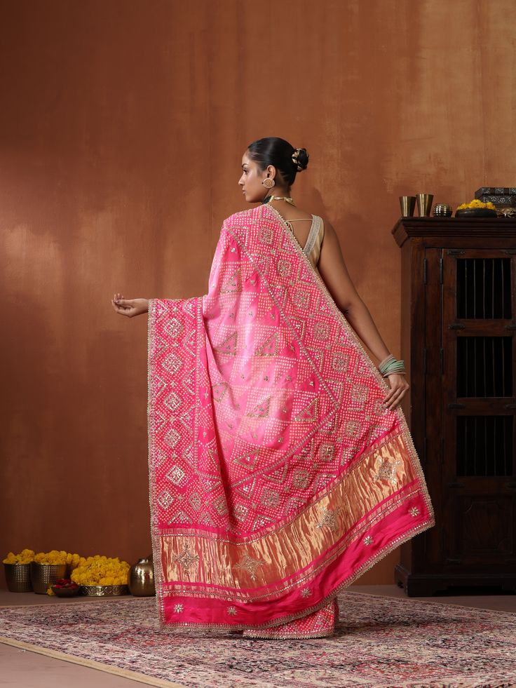 This Bandhani saree with Gotta Patti embroidery is a timeless masterpiece, blending traditional artistry with contemporary elegance. Crafted from pure Gajji silk in a striking red hue, it exudes grace and sophistication. Semi-stitched Chinon Saree With Motifs, Traditional Pre-draped Saree With Cutdana For Festivals, Bollywood Style Tussar Silk Pre-draped Saree With Motifs, Festive Katan Silk Pre-draped Saree With Dupatta, Traditional Designer Pre-draped Saree For Navratri, Festive Silk Pre-draped Saree With Motifs, Semi-stitched Bandhani Print Salwar Kameez In Dola Silk, Festive Bandhani Print Anarkali, Semi-stitched Dola Silk Salwar Kameez With Bandhani Print