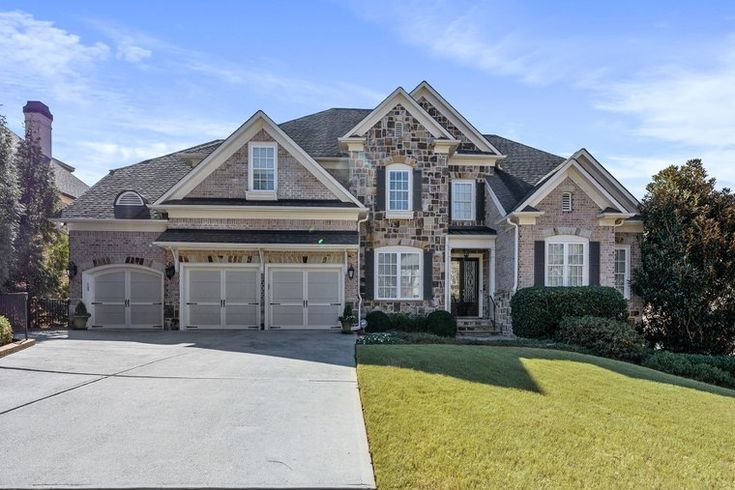 a large brick and stone house with two garages