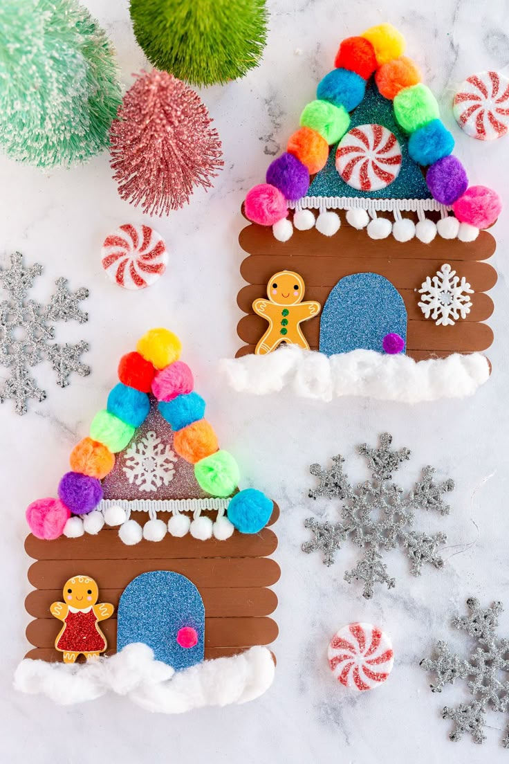 two gingerbread houses decorated with candy and snowflakes