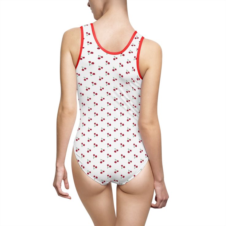 a woman wearing a white and red swimsuit with hearts on it's back