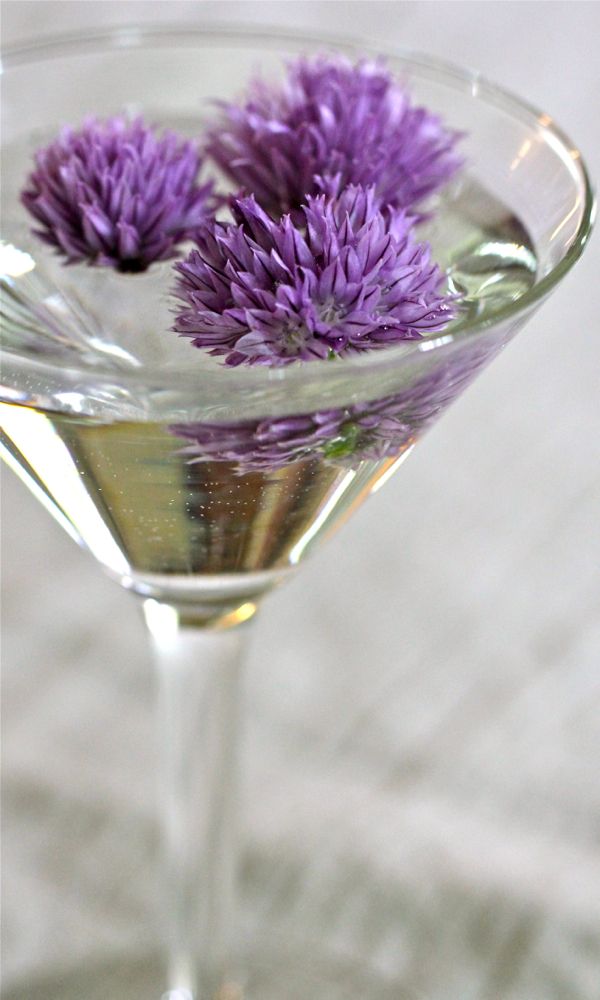 a martini glass with purple flowers in it