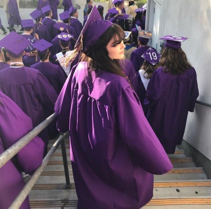 a group of people in graduation gowns walking up stairs