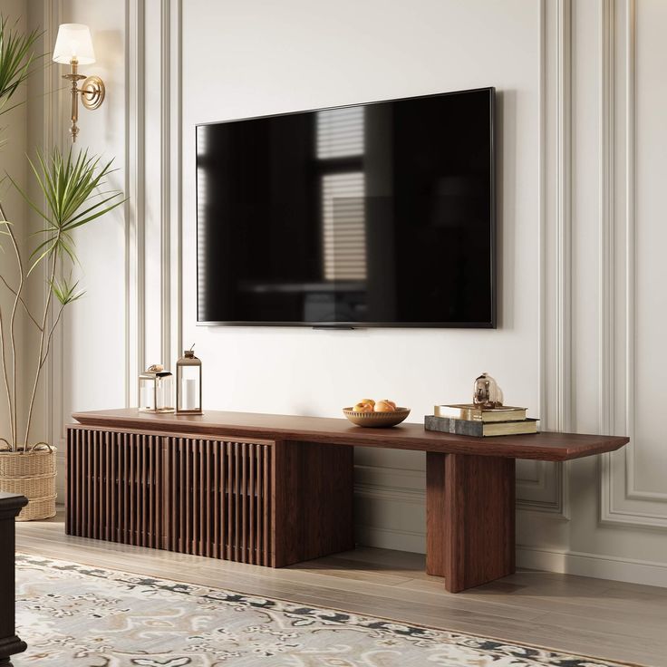 a flat screen tv mounted on the wall above a wooden table in a living room