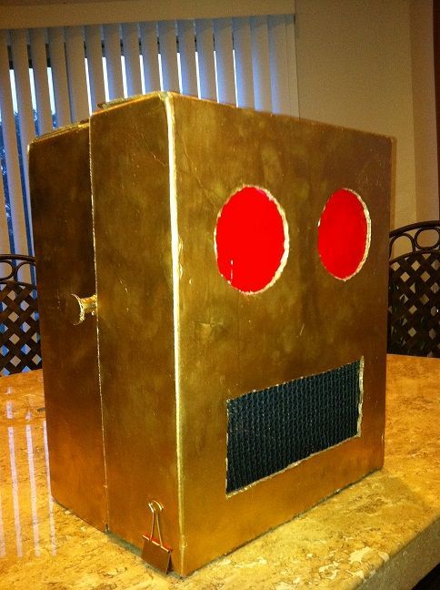 a golden box with red eyes on top of a table