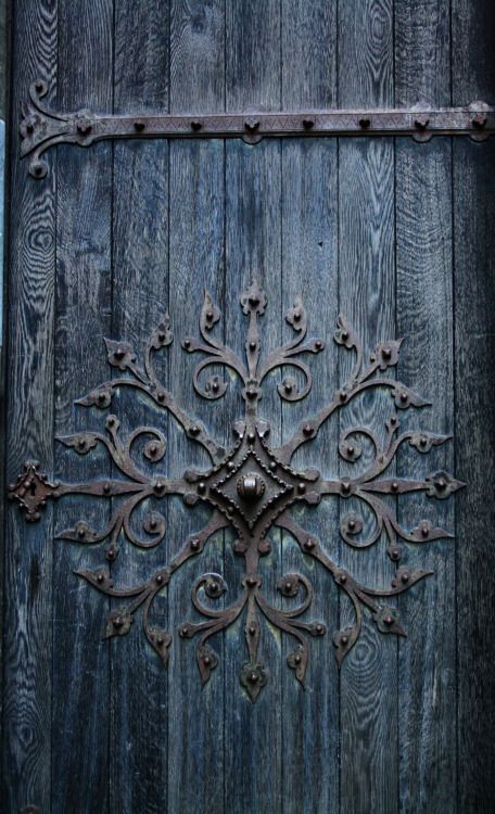 an old wooden door with iron work on it