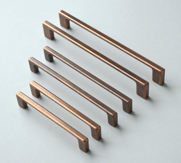 four different sizes of metal handles on a white surface