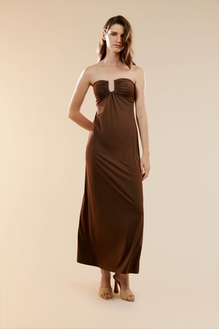 The perfect dress for hosting and attending parties. The Carolena Maxi Knit Dress is made from a chocolate brown stretch fabrication. It features a strapless design with a fitted bust and loose body for elevated movement. Pair with a nude heel to complete your occasion look.

SIZING: True to size. AU: Model wears a size 8 / US: Model wears a size 4.

FABRICATION: 85% nylon 15% elastane (Exclusive of trims)

- Maxi length
- Strapless
- Fitted bust Brown Sleeveless Ruched Maxi Dress, Brown Strapless Ruched Dress, Brown Ruched Midi Dress For Date Night, Chic Brown Fitted Strapless Dress, Brown Ruched Maxi Dress For Date Night, Brown Ruched Midi Dress For Night Out, Brown Strapless Dress For Night Out, Strapless Brown Dress For Night Out, Chic Brown Strapless Dress