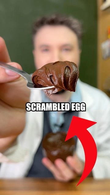 a man holding a chocolate covered donut with the caption scrambled egg