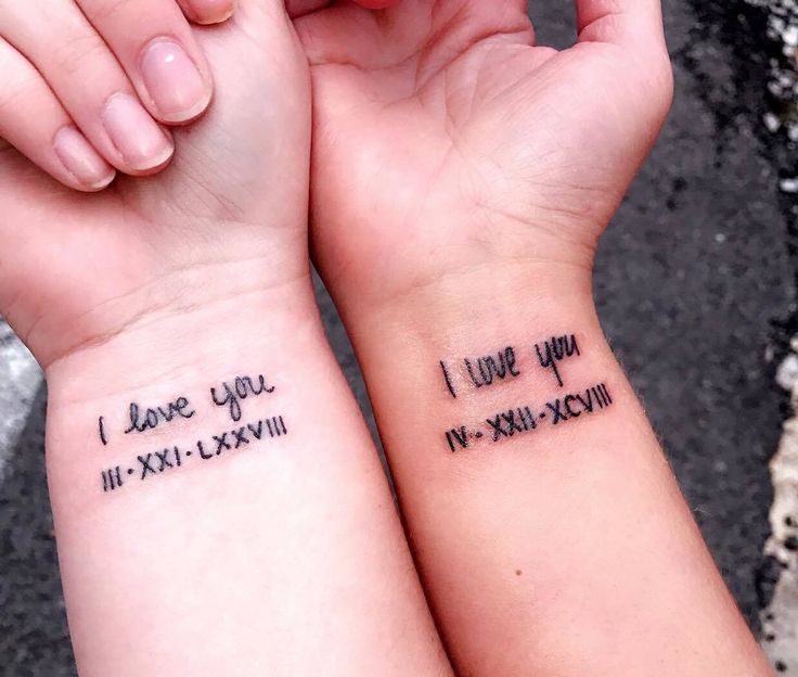 two people holding hands with tattoos on their wrists that say i love you and i love you