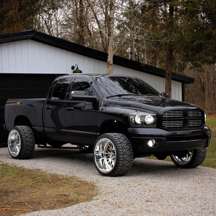 a black truck parked in front of a garage