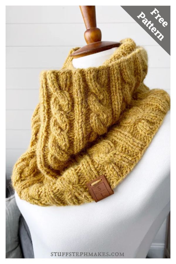 a yellow knitted cowl on a mannequin with a wooden hanger