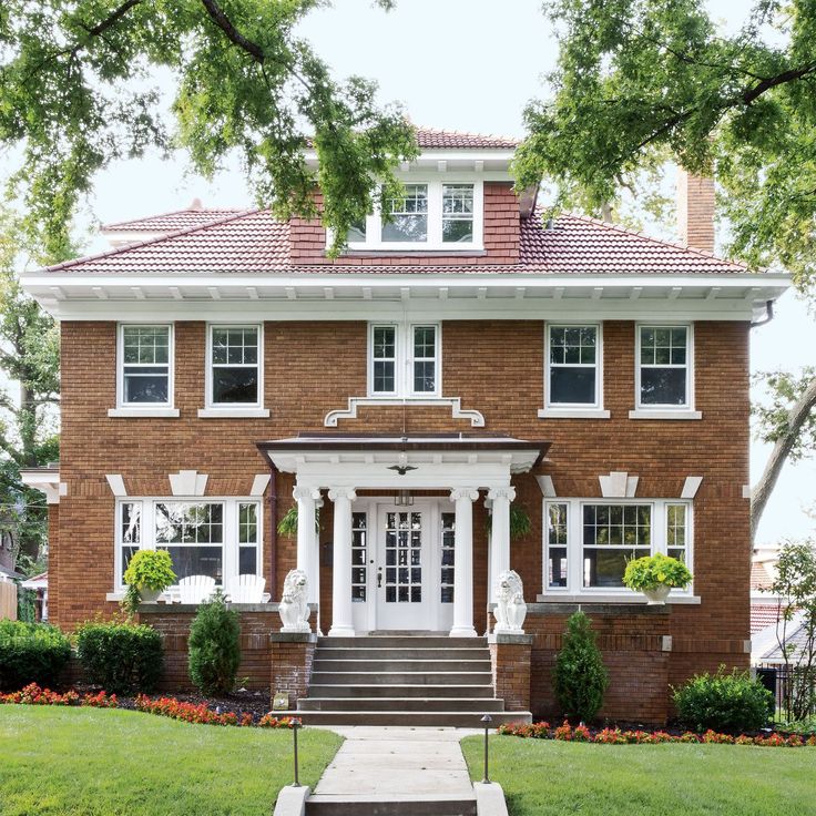 a large brick house with white trim on the front door and steps leading up to it