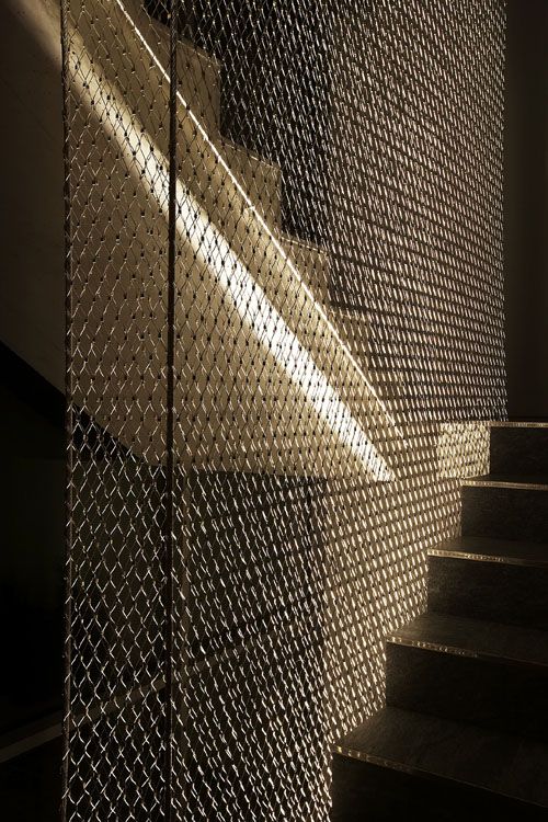 an image of stairs going up to the light coming in through the fenced door