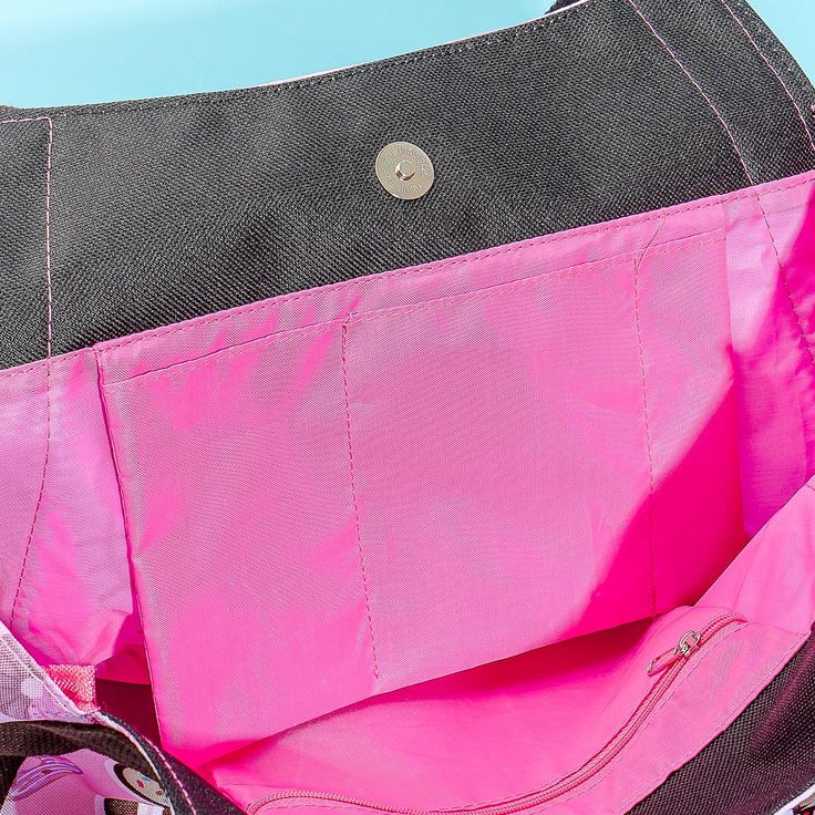 a pink and black purse sitting on top of a beach