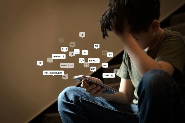 a young boy sitting on the stairs looking at his cell phone with speech bubbles coming out of it