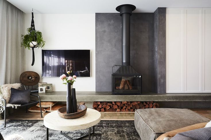 a living room filled with furniture and a fire place next to a wall mounted tv