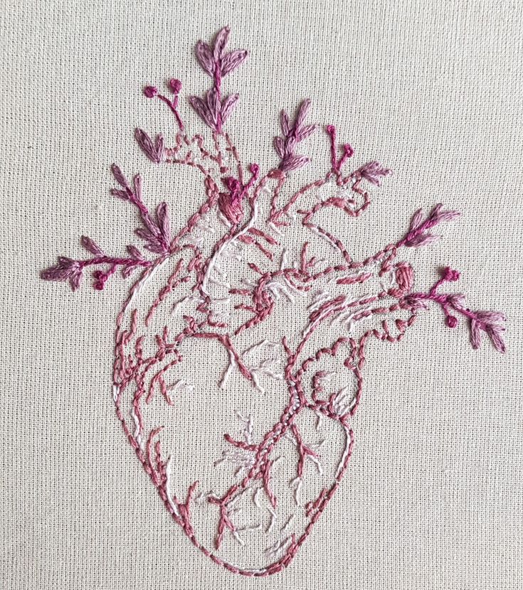 embroidered heart on white linen with pink flowers and leaves in the shape of a human heart