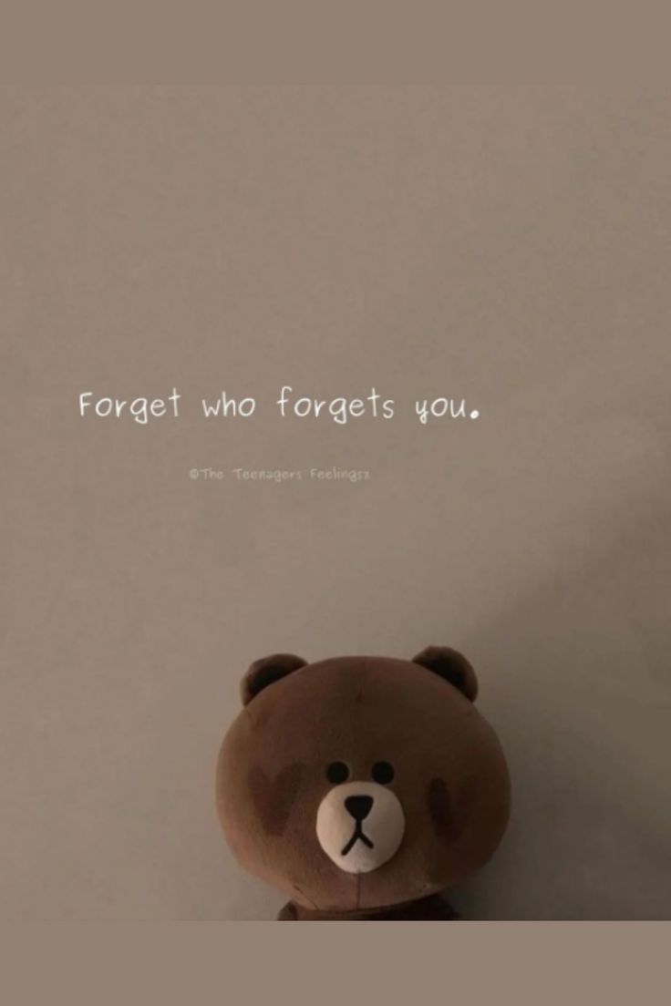 a brown teddy bear sitting on top of a white wall with a quote above it