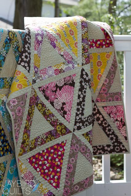 a colorful quilt is hanging on the back of a chair