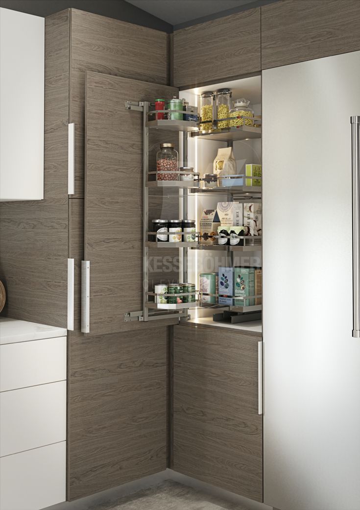 an open refrigerator door in a kitchen with white cabinets and wood grained panels on the doors