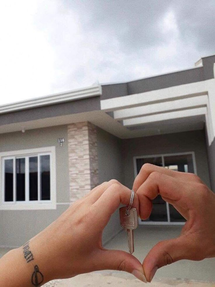 someone holding a house key in front of their home with the caption that reads, i love you