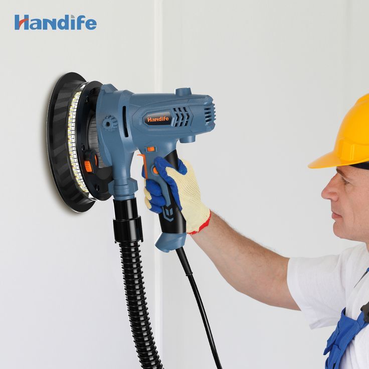 a man is using a power drill to fix a wall