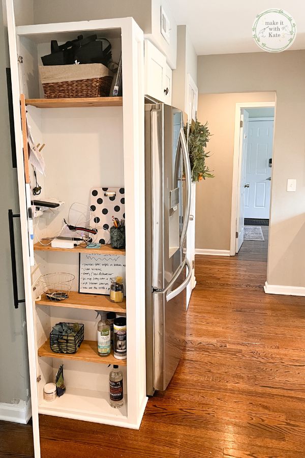 a kitchen with white cabinets and wood flooring in the center is filled with items