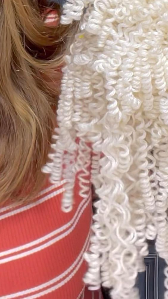 a close up of a woman's head with hair pulled back and braided in