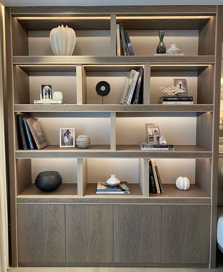 a bookshelf filled with lots of books and vases on top of it