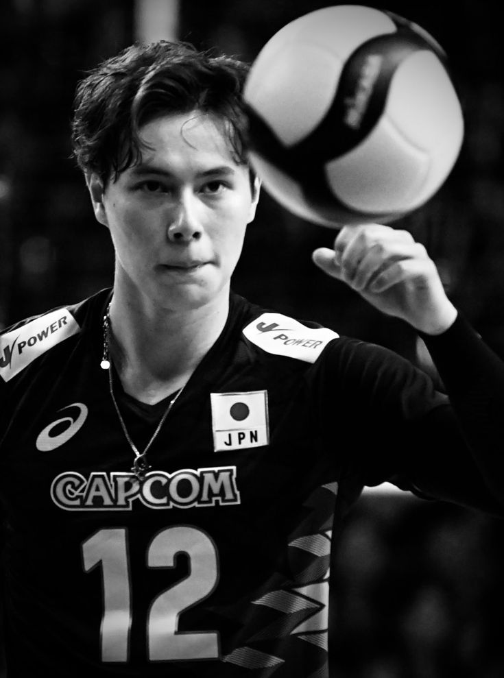 a young man is playing volleyball in black and white