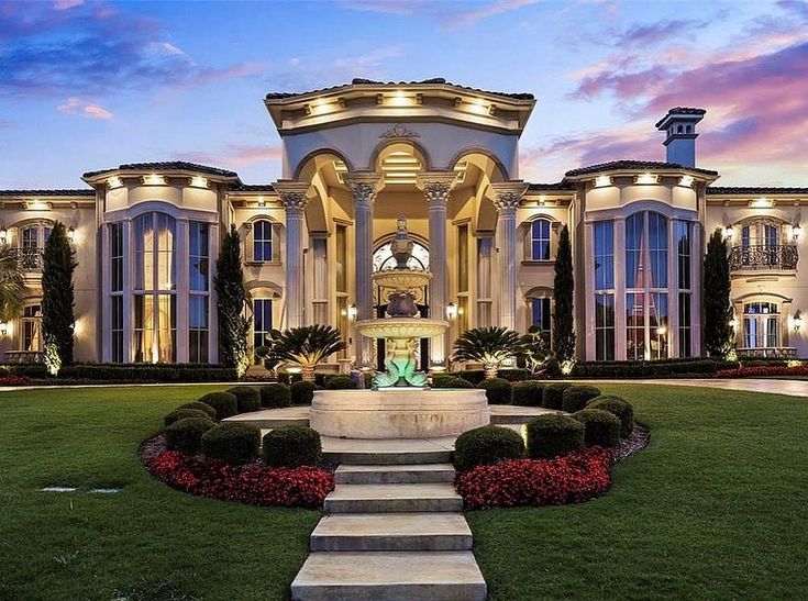 a large house with lots of windows and lights on it's front lawn area