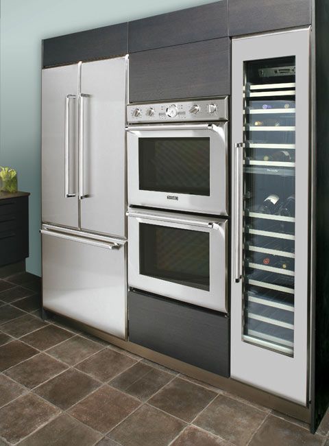 an oven and refrigerator in a kitchen with tile flooring