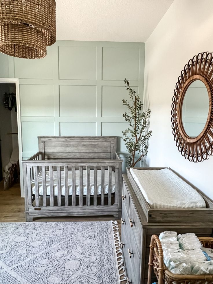 a baby's room with a crib, dresser and mirror