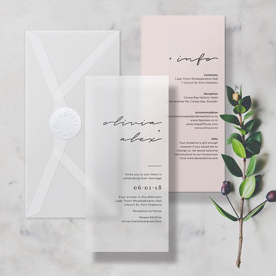 the wedding stationery is laid out on a marble surface with greenery and flowers