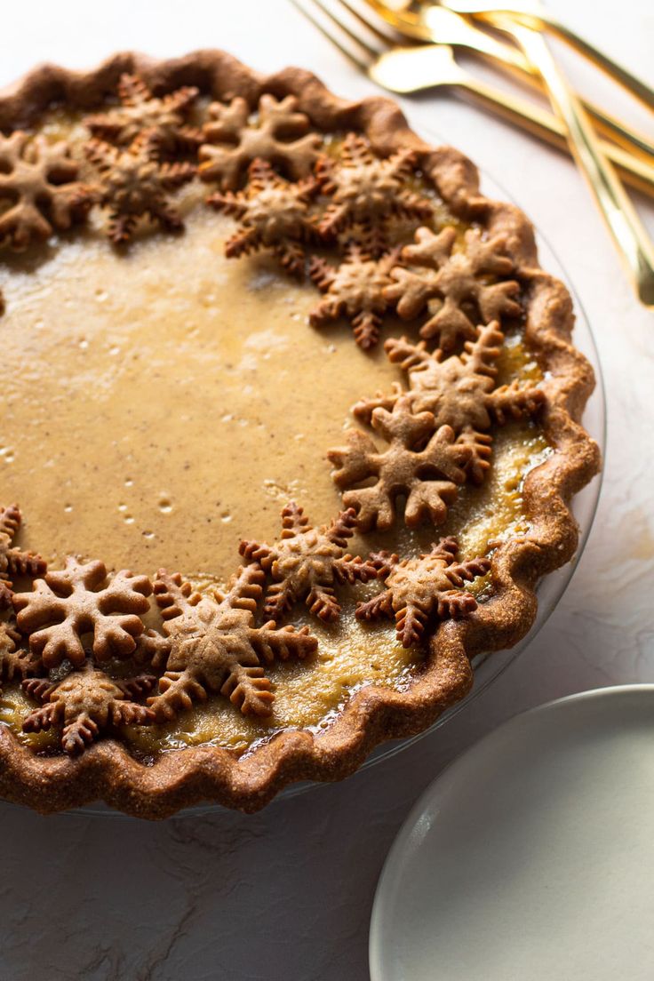 there is a pie on the table with gold forks