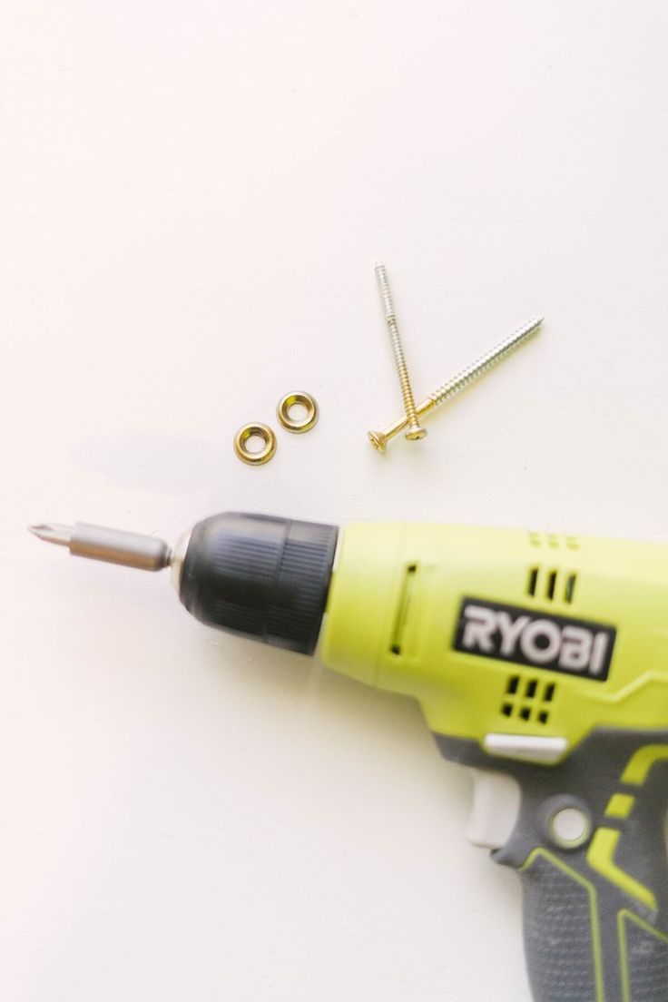 a drill and screwdriver on a white surface