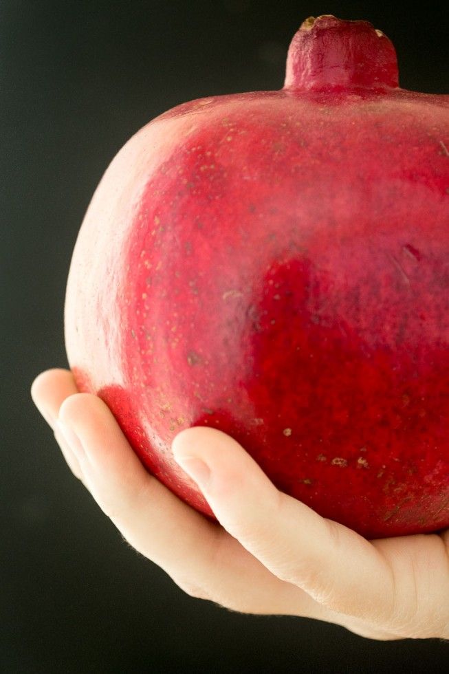 a hand holding an apple with the words 10 things to do with a pomegranate