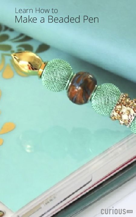 the beaded bracelet is sitting on top of a book with beads and gold accents