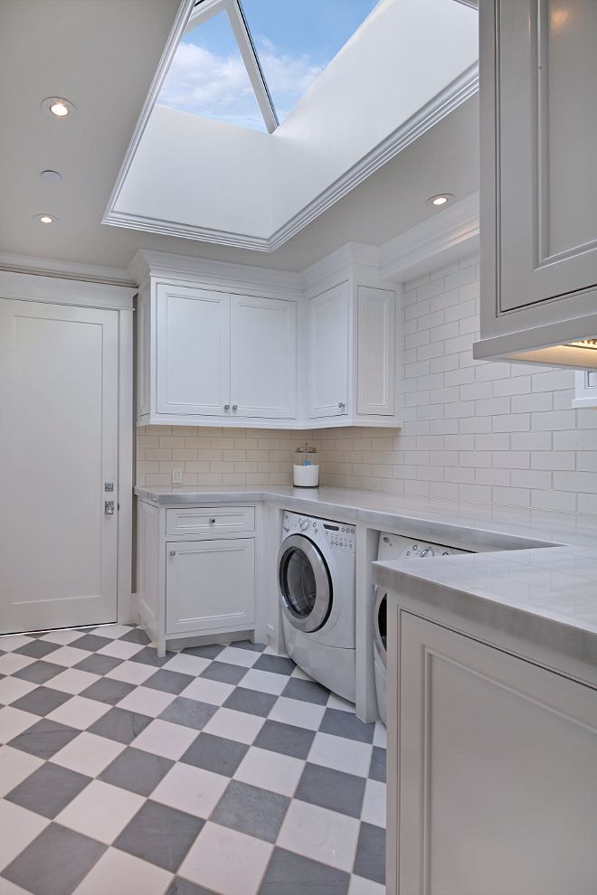 a kitchen with a checkered floor and skylight above the washer and dryer