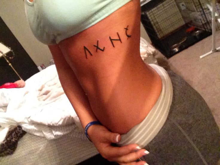 a woman with the word lax tattooed on her lower back and upper half of her stomach