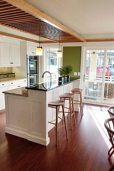 a kitchen with white cabinets and wooden floors