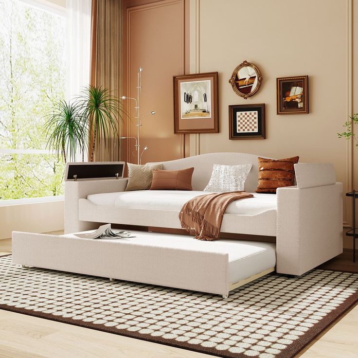 a white couch sitting on top of a rug in a living room next to a window