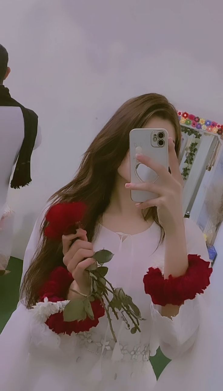 a woman is taking a selfie in front of a mirror with flowers on it