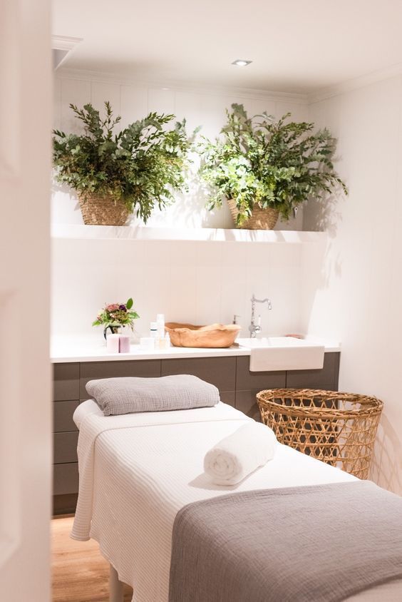 a couple of beds sitting next to each other in a room with plants on the wall