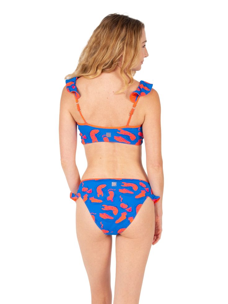 Double the Ruffle Fun with our matching Lola Bikini Bottom Make waves with our matching ruffle bikini bottom, designed to perfectly complement your Lola reversible ruffle bikini top! This flirty, feminine silhouette boasts the same playful ruffles, offering two chic patterns in one for endless mixing and matching possibilities. Dive into the details: Reversible design: Seamlessly switch between two vibrant patterns to match your mood and outfit. Fully reversible, two sided design. Flattering fit Vacation Swimwear With Ruffles And Tie-side Bottom, Beach Stretch Ruffle Tankini, Playful Ruffled Tankini For The Beach, Stretch Ruffle Tankini For The Beach, Stretch Ruffles Tankini For Beach, Fitted Swimwear With Ruffled Straps For Beach, Blue Swimwear With Ruffled Straps For Poolside, Blue Vacation Swimwear With Ruffled Straps, Blue Ruffled Strap Swimwear For Poolside