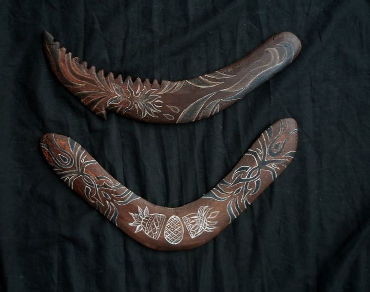 two carved wooden objects sitting on top of a black cloth