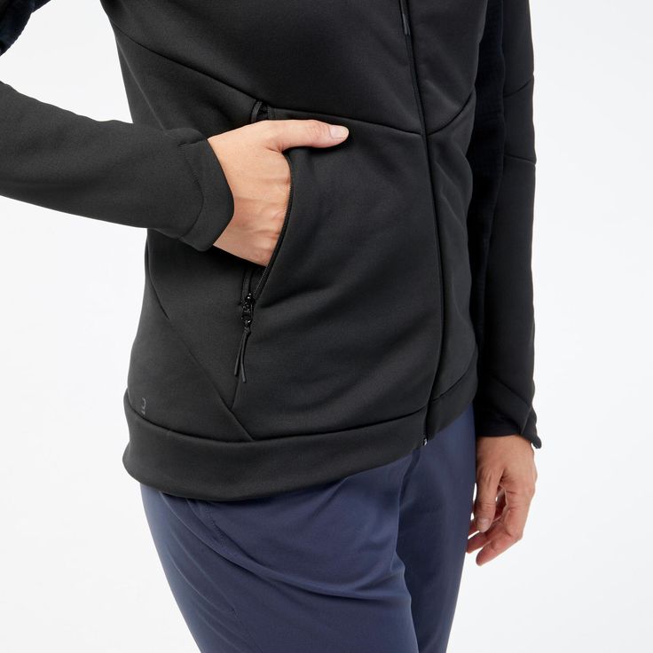 a woman wearing a black hoodie with her hands on her hip and the bottom half of her body